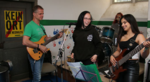 Proben gegen Rechts mit BAFF, Foto: Susanne Liedtke, Ein Mann und zwei Frauen spielen Gitarre, Bass, Gesang, dahinter ein Schild "Kein Ort für Neonazis"