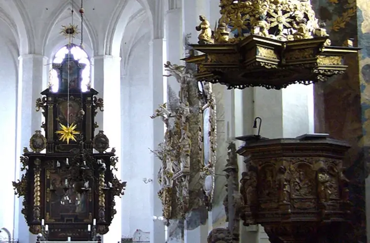 Ein Kirchenraum mit schmuckvollem Altar und Kanzel.