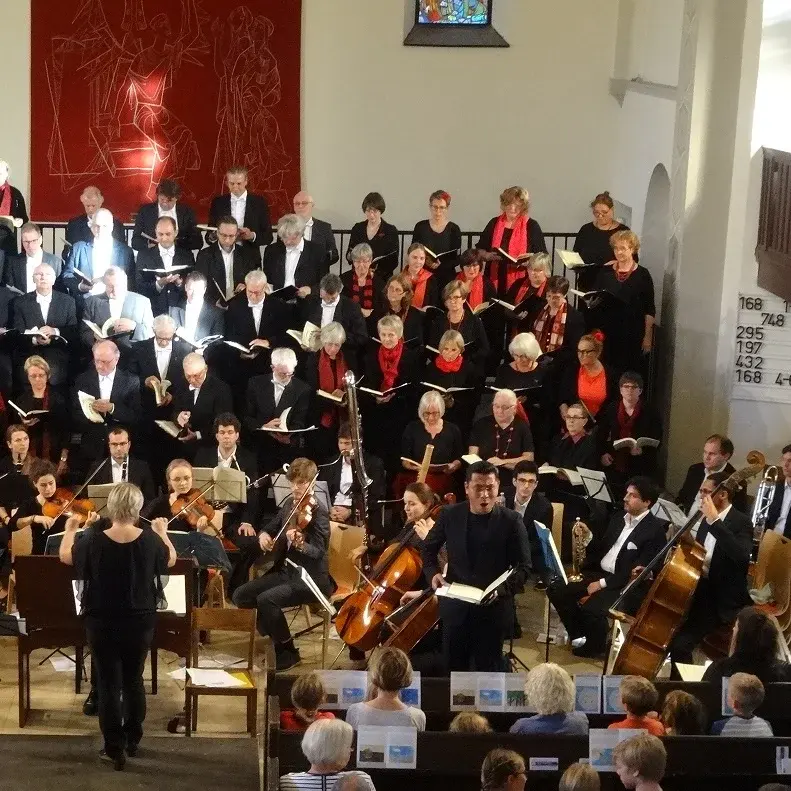 Ein Chor und ein Ensemble, das in einer Kirche spielt.