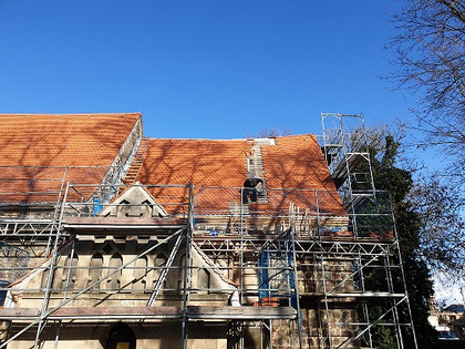 Hier sieht man, wie das Dach der Rehfelder Kirche neu eingedeckt wird.