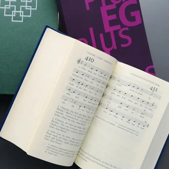 Mehrere Ausgaben von Gesangbüchern, ein Gesangbuch ist aufgeschlagen.
