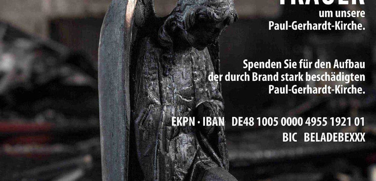 Man sieht einen verkohlten Engel, "Trauer um unsere Paul-Gerhardt-Kirche" und das Spendenkonto.