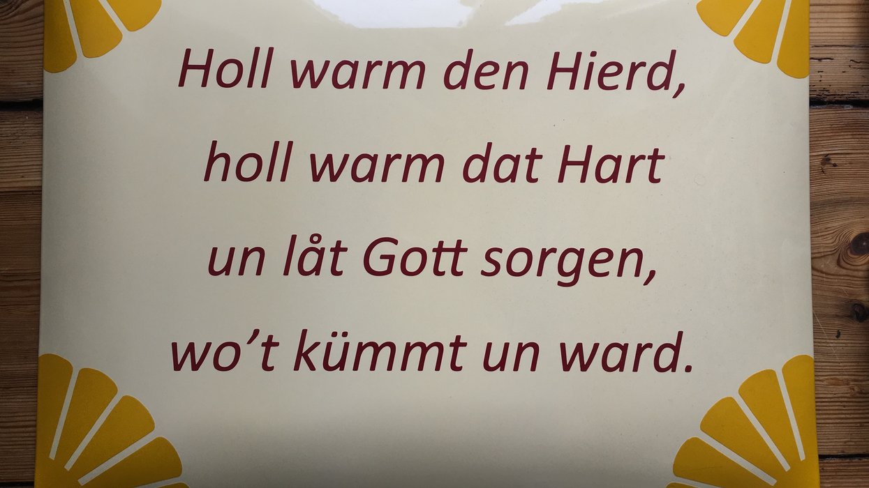 Haustafel, auf der steht ,,Holl warm den Hierd, holl warm dat Hart un lat Gott sorgen, wo't kümmt un ward''.